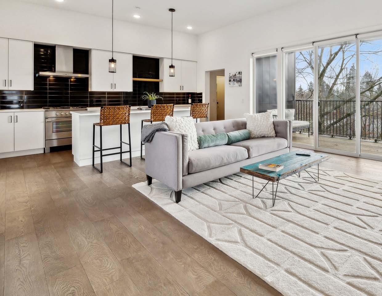 Open concept living room and kitchen at Wygant Flats with Portland skyline view